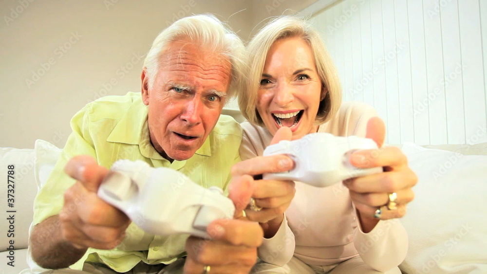 Retired Couple Competing on Games Console Retired Couple Competing on Games Console