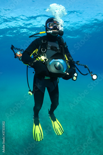 Underwater photographer with big camera and flashes.