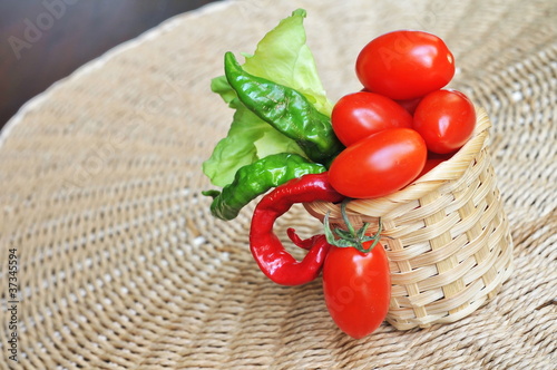 Tomatoes, peppers and salad in wicker basket