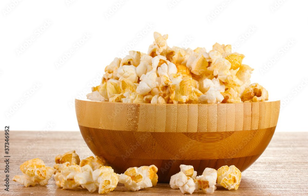 popcorn in wooden bowl on wooden table on white background popcorn in wooden bowl on wooden table on white background