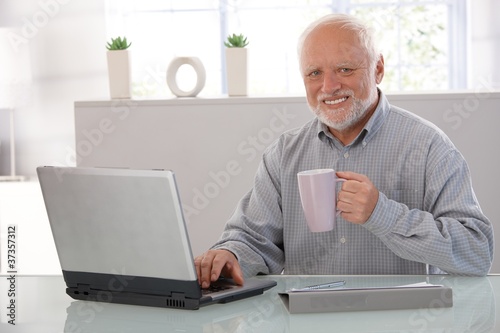 Mature man with computer smiling photo