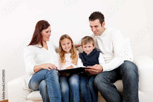 Hapy young family watching photo album