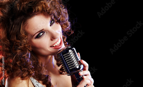 Portrait of a glamorous girl with mike singing song
