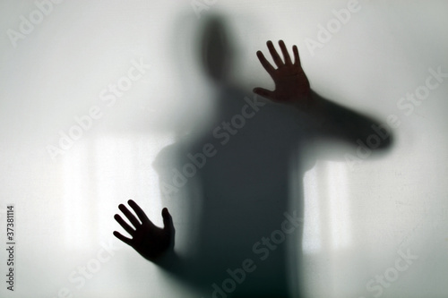 Slika na platnu Shadowy figure behind glass