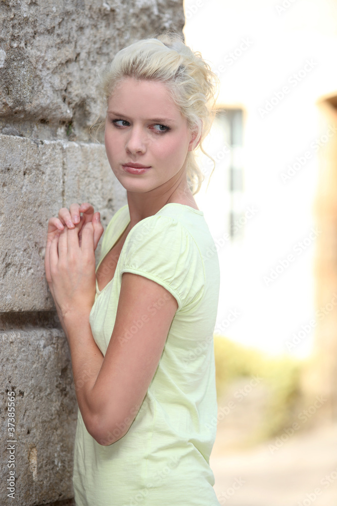 Young woman posing against a stone building Young woman posing against a stone building