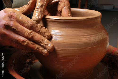 hands of a potter, creating an earthen jar on the circle