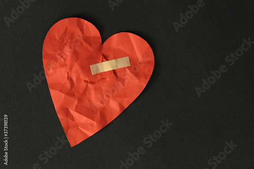 broken red heart on black background