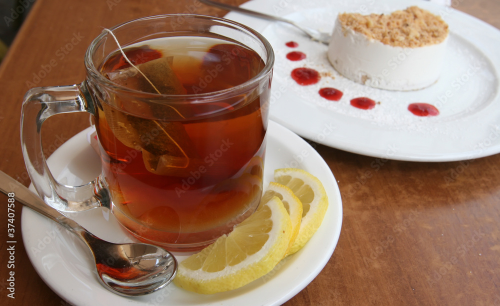 A cup of tea with lemon and a cake A cup of tea with lemon and a cake