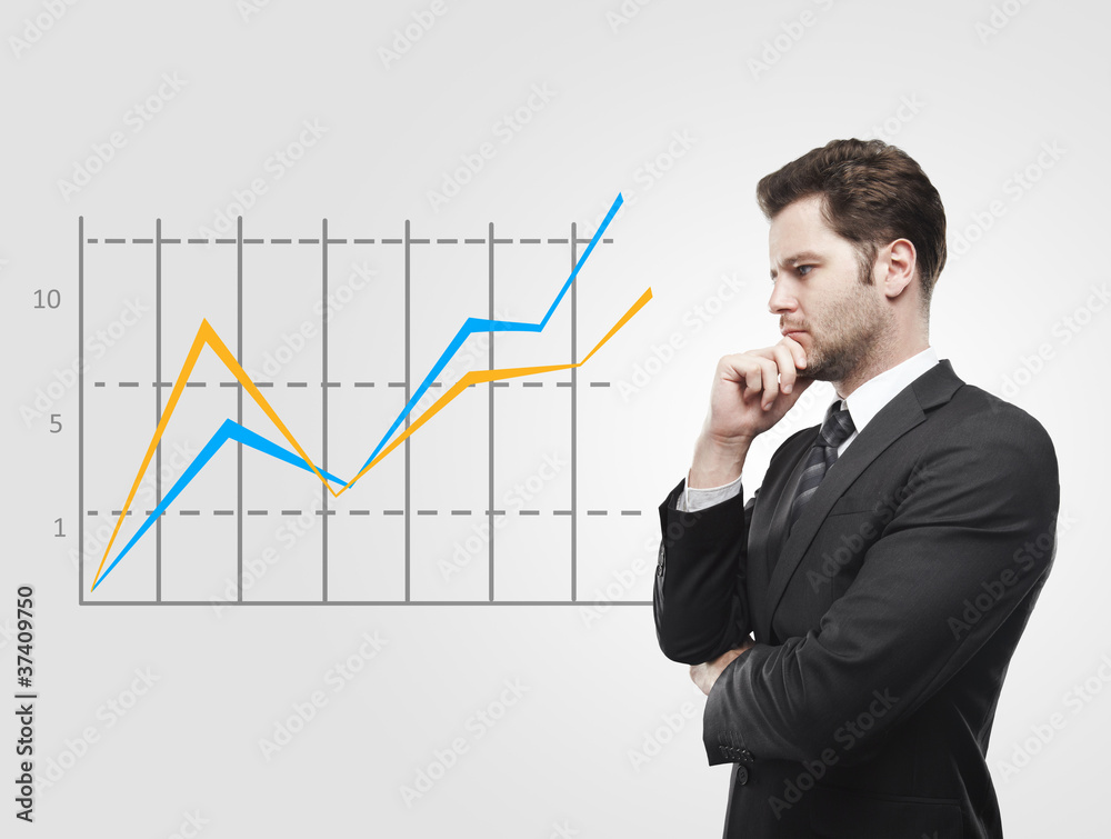 Young business man look at a graph Young business man look at a graph