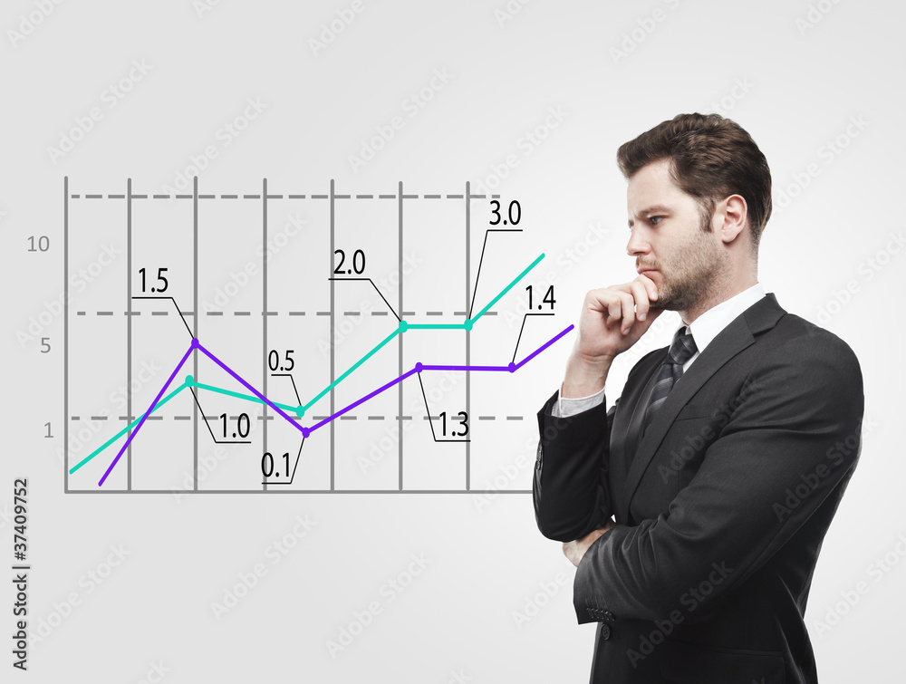 Young business man look at a graph Young business man look at a graph