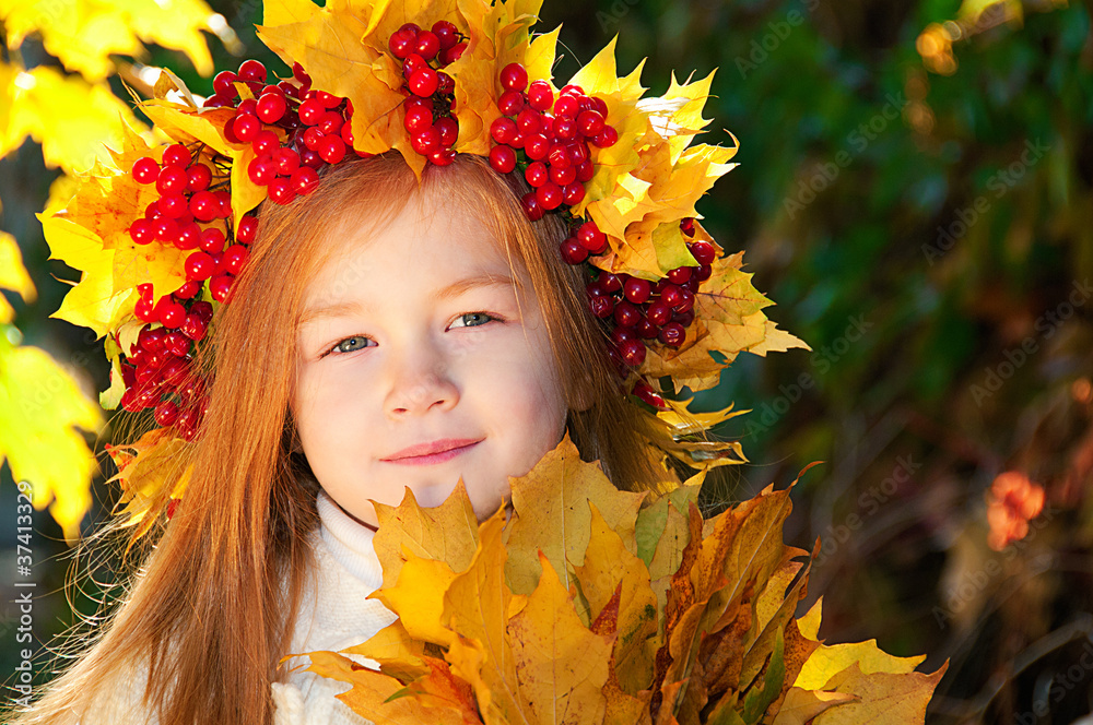 Cute smiling girl in a wreath of red viburnum on the head