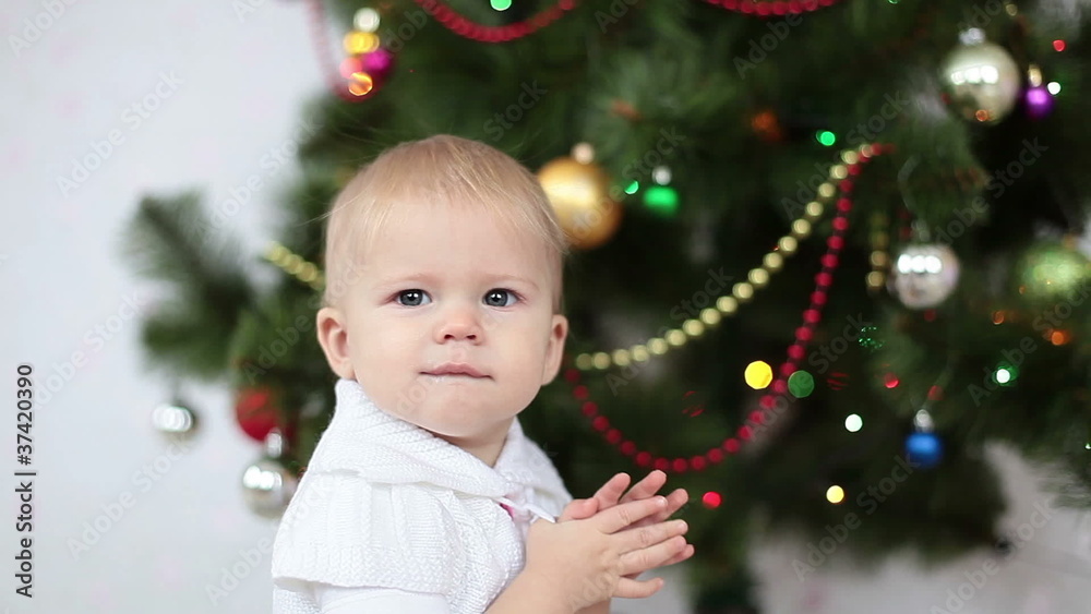 Baby girl yawns beside the Christmas Tree Baby girl yawns beside the Christmas Tree