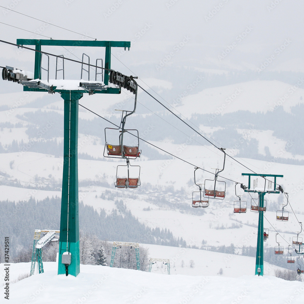 Winter morning mountain landscape with ski lift and skiing slope Winter morning mountain landscape with ski lift and skiing slope