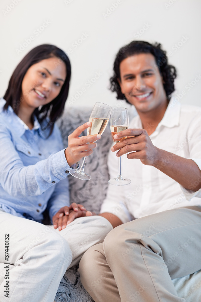 Couple celebrating with sparkling wine in the living room Couple celebrating with sparkling wine in the living room
