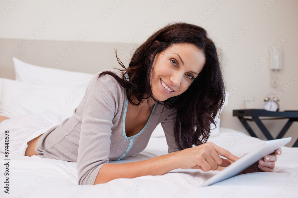 Smiling woman with tablet on the bed Smiling woman with tablet on the bed