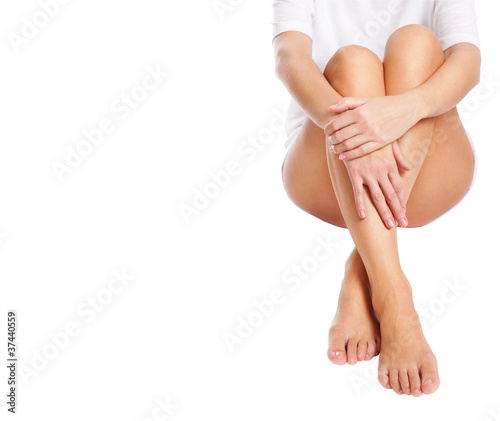 cut out slender naked female legs being massaged isolated on whi