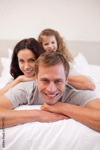 Cheerful family relaxing on the bed together © WavebreakmediaMicro