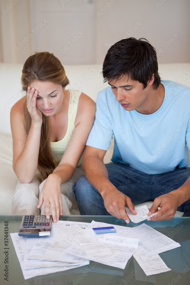 Portrait of a worried couple looking at their bills Portrait of a worried couple looking at their bills