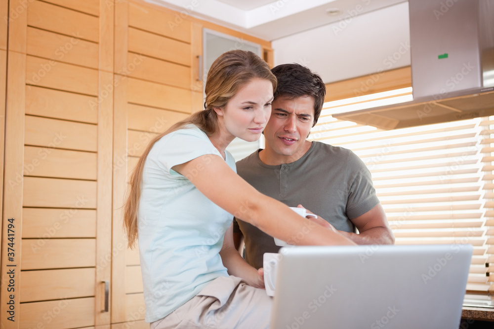 Young couple having tea while using a laptop Young couple having tea while using a laptop