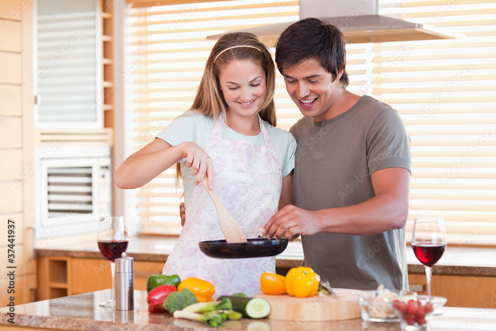 Couple cooking dinner while drinking red wine