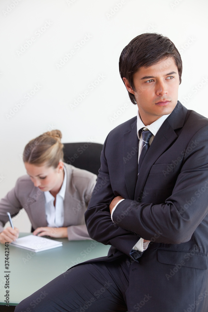 Portrait of a manager posing while his colleague is working Portrait of a manager posing while his colleague is working