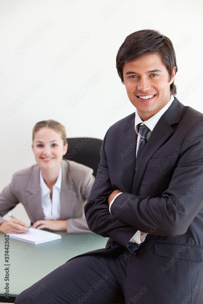 Portrait of a businessman posing while his colleague is working Portrait of a businessman posing while his colleague is working