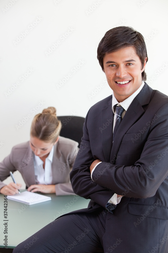 Portrait of an office worker posing while his colleague is worki Portrait of an office worker posing while his colleague is worki