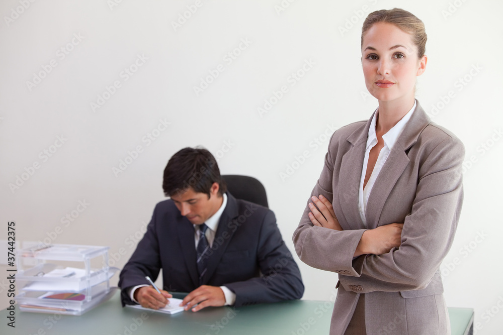 Businesswosman posing while her colleague is working Businesswosman posing while her colleague is working