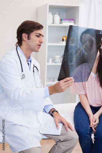 Male doctor analyzing x-ray with his patient