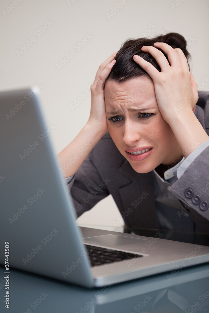 Businesswoman experiencing trouble with her laptop Businesswoman experiencing trouble with her laptop