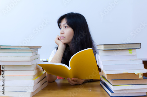 Bored  college student in uniform with stack of books