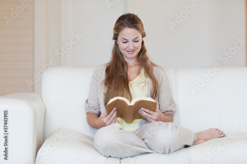 Woman reading a novel on the sofa