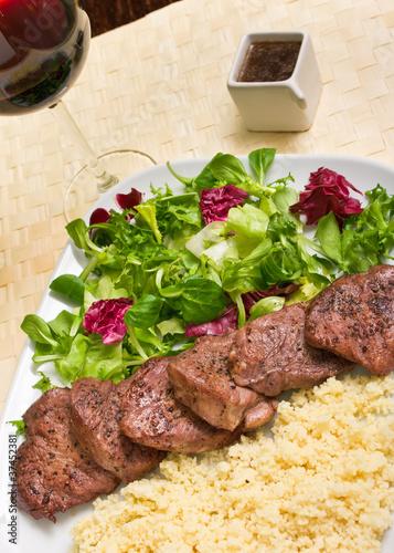 Tenderloin steaks in wine sauce with cadamon and kuskus groats photo