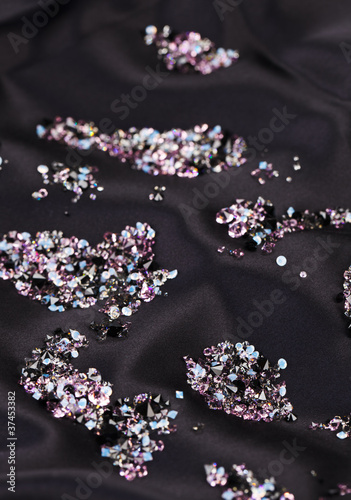 Fototapeta Naklejka Na Ścianę i Meble -  Diamond (small purple jewel) stones heap over black silk cloth b