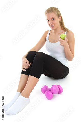 young blondie woman sitting with dumbbells and apple