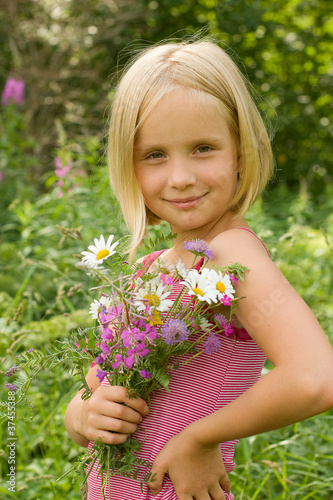 Beautiful Smiling Girl with Meadow Flowers Outdoor