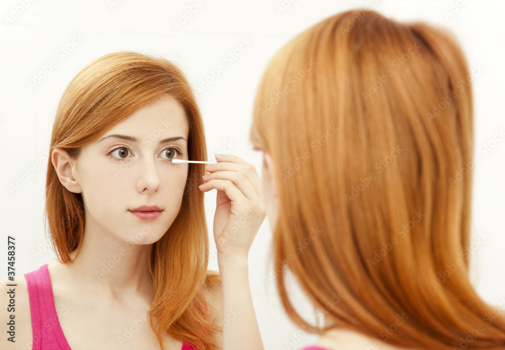 Beautiful redhead young woman with fresh skin of face in bathroo Beautiful redhead young woman with fresh skin of face in bathroo