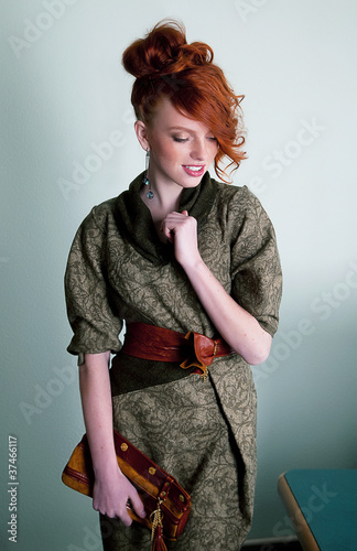 Hedihaired young woman in fashion dress witn hand bag photo