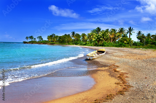 Fotografia Jamaica. A national boat on sandy coast of a bay