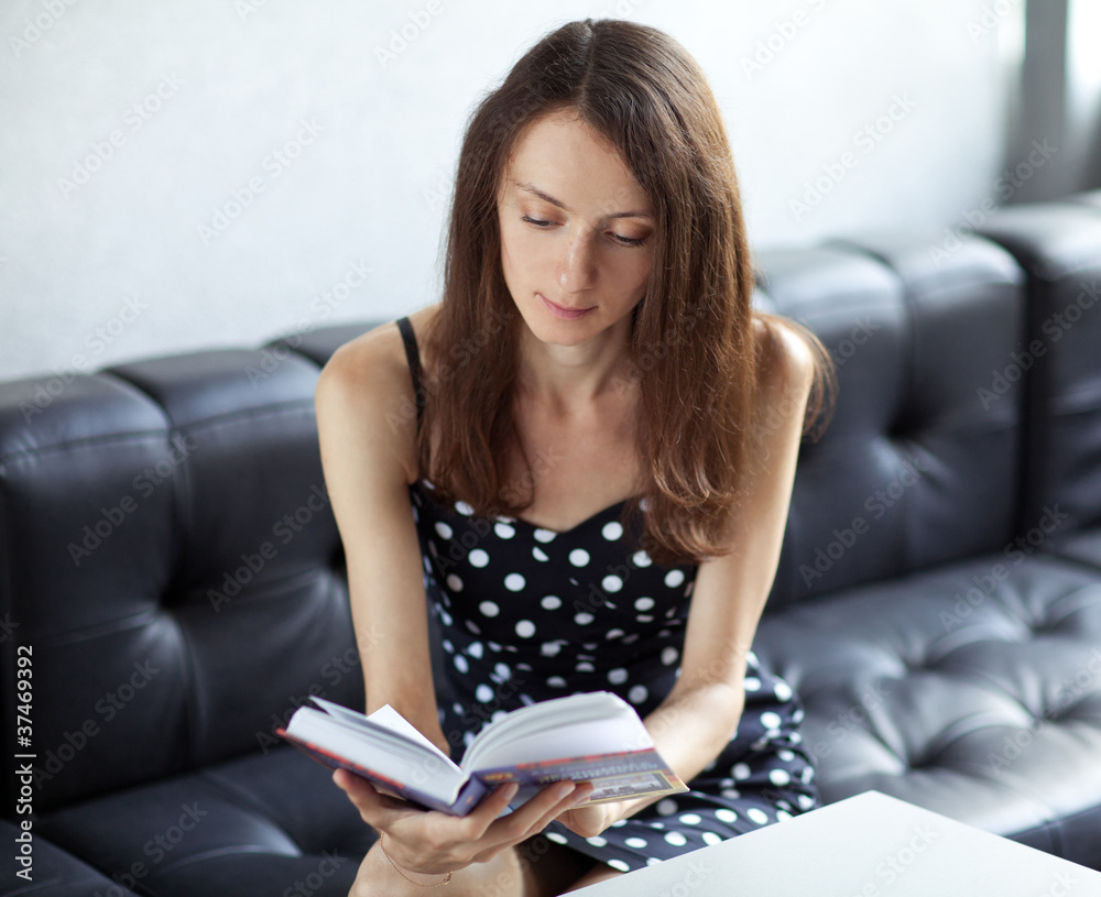 Young brunette student reading a book Young brunette student reading a book