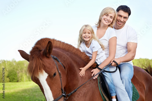 Attractive family on a brown horse