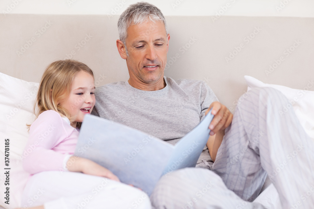 Father reading a story to his daughter Father reading a story to his daughter