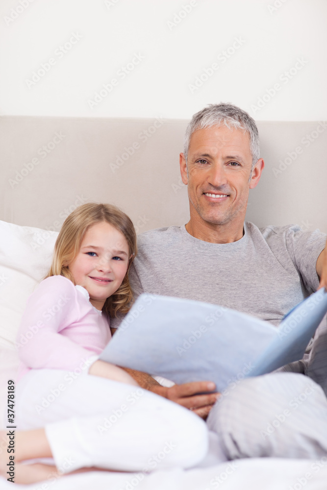 Portrait of a father reading a story to his daughter Portrait of a father reading a story to his daughter