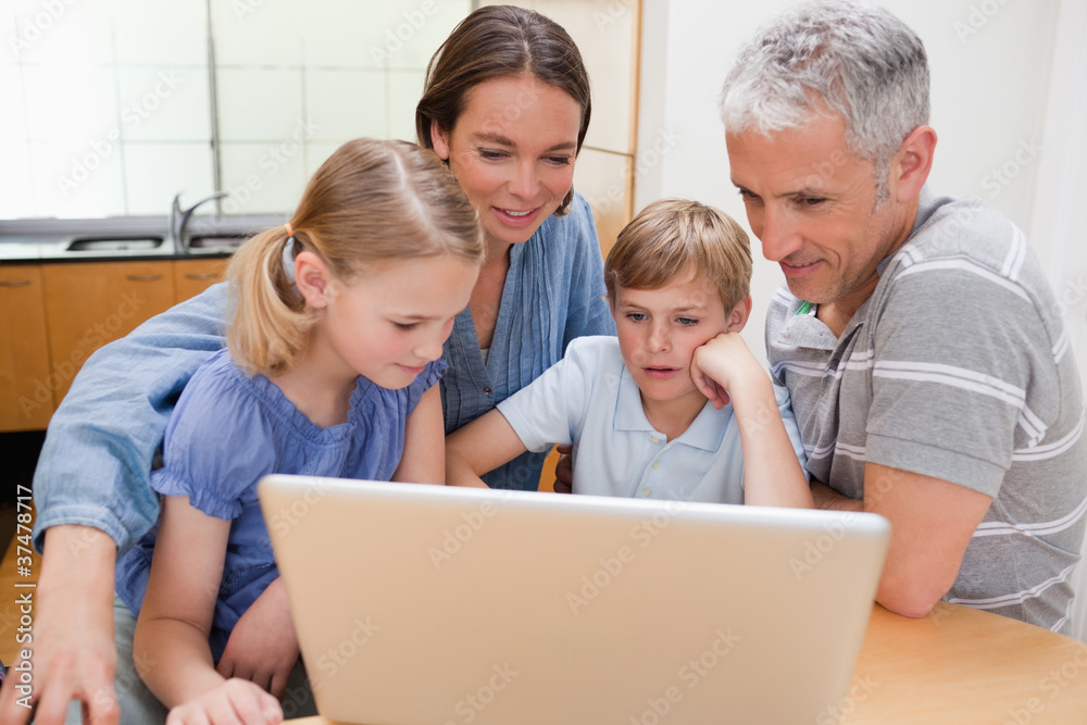 Charming family using a notebook Charming family using a notebook