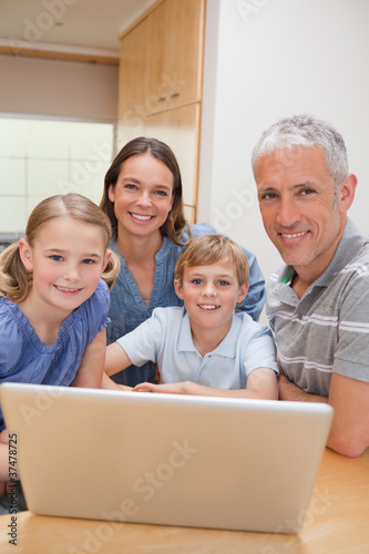 Portrait of a charming family using a laptop