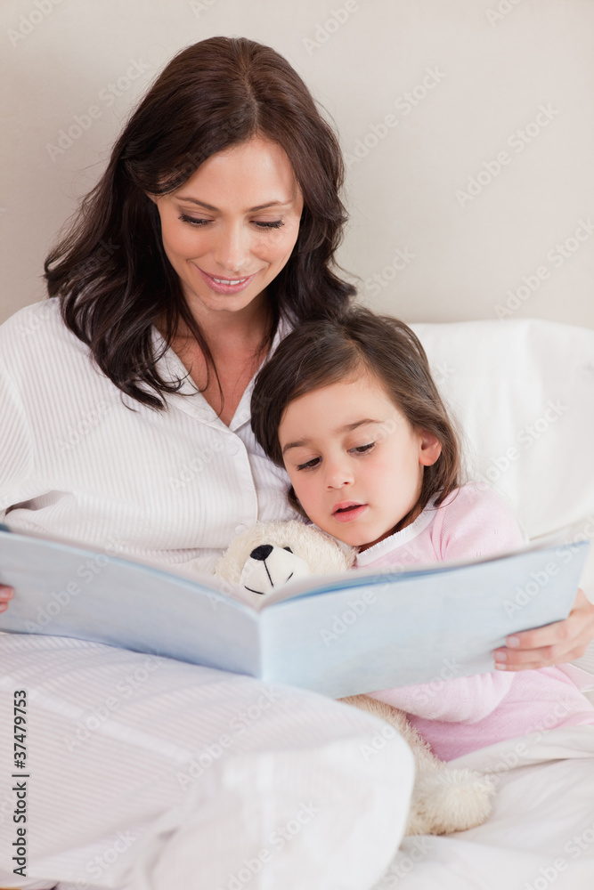 Portrait of a mother reading a story to her daughter Portrait of a mother reading a story to her daughter