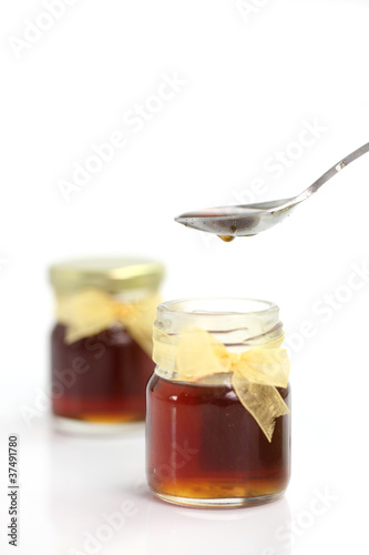 honey dripping from drizzler on top of jar, 