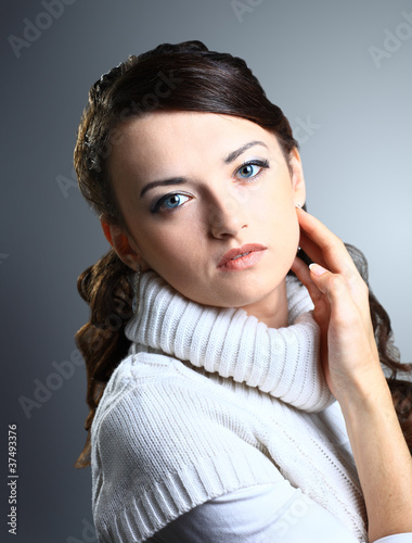 Thoughtful beautiful girl in sweater. Isolated on a