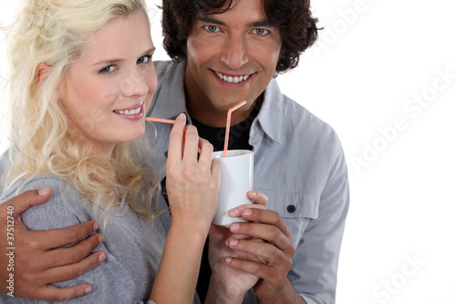 lovely couple drinking out of same cup with straw