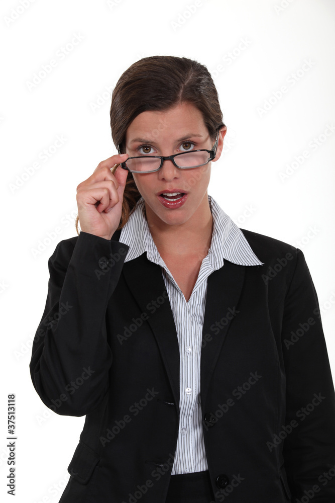 Young employee watching over her eyeglasses Young employee watching over her eyeglasses